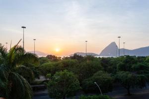 einen Sonnenuntergang über einem Park mit einem Berg im Hintergrund in der Unterkunft Kit Rio - vista mais linda do RJ in Rio de Janeiro