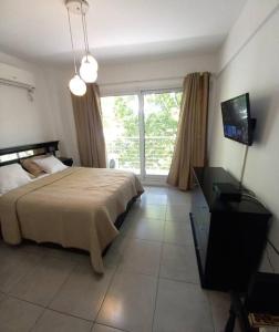 1 dormitorio con 1 cama y TV en Dos ambientes con cochera La Boca/ San Telmo en Buenos Aires