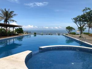 a large swimming pool with the ocean in the background at Villa Sapphire9 Aria Vungtau in Xa Thang Nhut