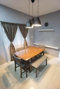 a dining room with a wooden table and chairs at Akmal Homestay Klang in Klang