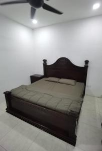 a bed in a room with a ceiling fan at Akmal Homestay Klang in Klang