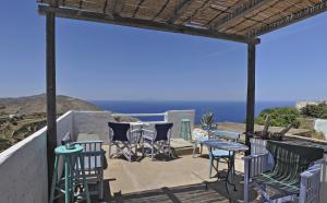 a patio with chairs and tables and the ocean at Kyma sto Phos in Chora Folegandros