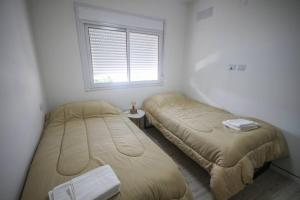 2 camas en una habitación con ventana en Super céntrico, amplio y equipado - Ideal Consulado España en Bahía Blanca