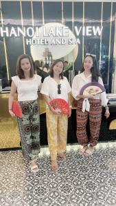 drie vrouwen staan voor een winkel bij Lake View Hotel & Travel in Hanoi