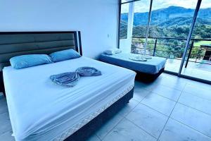 a bedroom with a bed and a large window at Buena vista Casa Quinta con Piscina y Mirador in Carmen de Apicalá