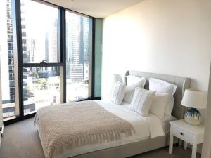 1 dormitorio con cama blanca y ventana grande en Luxury 3 Bed 2 Bath + car park at Melbourne Square, en Melbourne