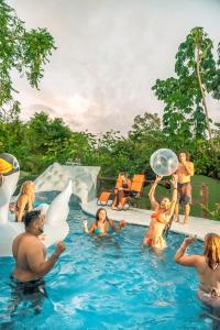 um grupo de pessoas na água em uma piscina em Kalea Yard Hotel em Puerto Jiménez