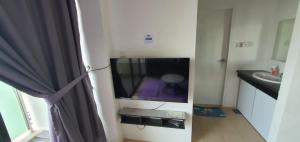a bathroom with a tv in a room with a sink at Bunny Homestay 407 Roxy Apartment Kuching in Kuching