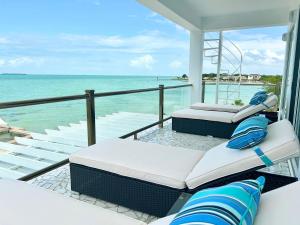 two beds on a balcony overlooking the ocean at Villas Secreta Beachfront Resort in San Pedro