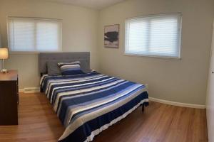 a bedroom with a bed with a blue and white striped blanket at Quiet & Cozy home near Hospitals in Cleveland