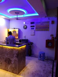 a man sitting at a counter in a restaurant with purple lights at HOTEL S S PALACE in Agra