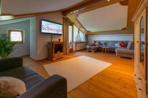 a living room with a couch and a tv at Ferienwohnungen Schweiger in Ruhpolding