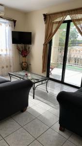 un soggiorno con divano e tavolo in vetro di Vacation Home La Ceiba a La Ceiba