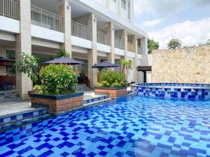 einem Pool vor einem Gebäude in der Unterkunft Bueno Colombo Hotel Yogyakarta in Kalasan