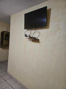 a flat screen tv on the corner of a wall at Hotel villas la aurora in Bernal