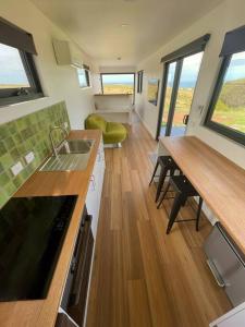 a kitchen with a sink and a table in a house at Bay of Fires Tiny Home in Binalong Bay