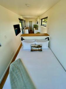 a small bedroom with a large bed in a house at Bay of Fires Tiny Home in Binalong Bay