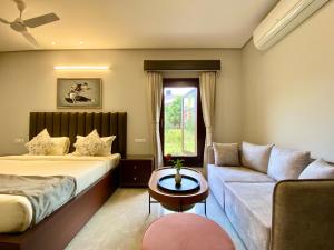 Vastu Homestay, Dehradun في دهرادون: غرفه فندقيه بسرير واريكه