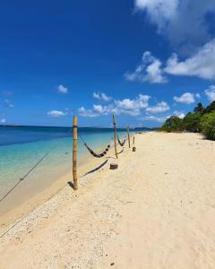 a hammock on a sandy beach near the ocean at Pili Beach Resort Agmanic in Santa Fe