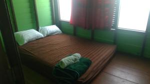 a bed in a room with two windows at Crazy Monkey in Trat