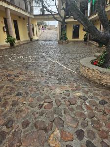 a cobblestone street with a tree and a building at Hotel villas la aurora in Bernal