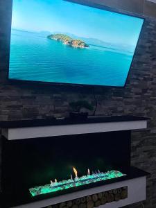 a flat screen tv above a fireplace with flames at Exclusivo Apartastudio Zona Norte de Bogota in Bogotá