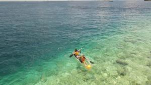 a person is paddling a kayak in the water at iHaven Thulusdhoo in Thulusdhoo