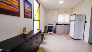 a kitchen with a refrigerator and a counter top at Chalé Amarelo in Itanhaém +44 photos