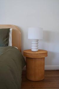 a lamp on a night stand next to a bed at Sunset Beach House in Soldiers Point