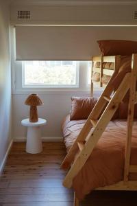a bedroom with two bunk beds and a window at Sunset Beach House in Soldiers Point