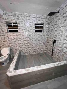 a bathroom with a bath tub with a toilet at Nature World St.Lucia in Castries