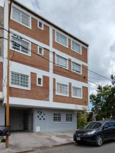 a building with a car parked in front of it at M&M Depto in Cipolletti