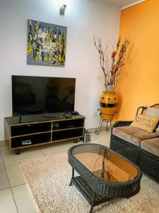 un soggiorno con TV e divano di Appartement élégant proche de Yaoundé Centre a Yaoundé