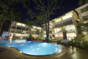 una piscina frente a un edificio por la noche en Eternal wave by HappyInch, en Calangute