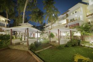 a building with white umbrellas in a yard at Eternal wave by HappyInch in Calangute