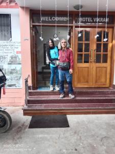 two people standing on the steps of a building at Hotel vikram in Khajurāho