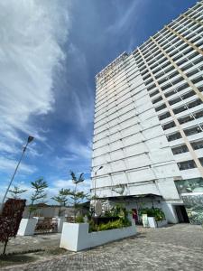 a tall white building with a sky in the background at Super Deluxe Apartment with Skypool Medan in Sunggal