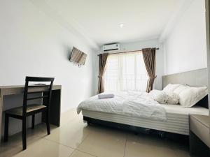 a bedroom with a bed and a desk and a chair at Super Deluxe Apartment with Skypool Medan in Sunggal