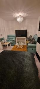 sala de estar con 2 sillas y lámpara de araña en Trundle bed- with office desk, small room en Newhaven