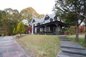 a large black house with a grass yard at Lodge Kent in Hokuto