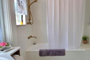 uma casa de banho branca com uma banheira e um lavatório em JDs Tropical stays em Cairns