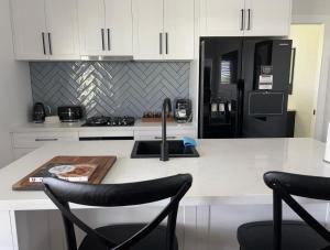 a kitchen with a sink and a black refrigerator at The Shaddy Rest secluded resort for the perfect romantic getaway in Orange