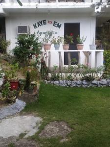 une maison avec des plantes en pot dans la cour dans l'établissement Kaye En Em Apartelle, à Puerto Galera