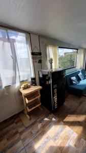 a living room with a black refrigerator and a table at Aparta estudio Colorido in Bogotá