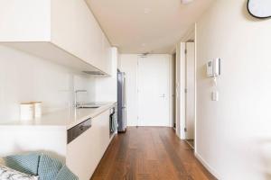 uma cozinha com um lavatório e uma bancada em Beachside flat with free parking em Melbourne