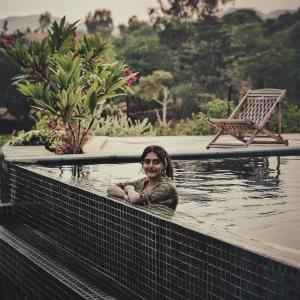 a woman standing in a pool of water at The Riverside Estate - 2Bedroom Private Pool Villa in Udaipur in Udaipur