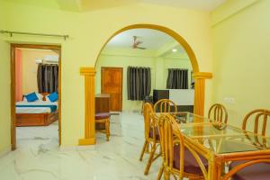 a living room with a dining table and a bedroom at A&A BNB in Port Blair
