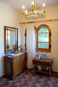baño con lavabo, ventana y lámpara de araña en All Seasons Guest House, en Moscháton