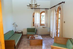 sala de estar con 2 sillas verdes y mesa en All Seasons Guest House, en Moscháton
