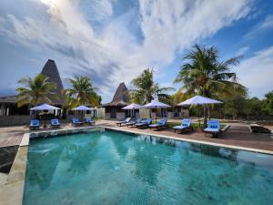 a pool at a resort with chairs and umbrellas at KANDORA Luxury villas in Maujawa